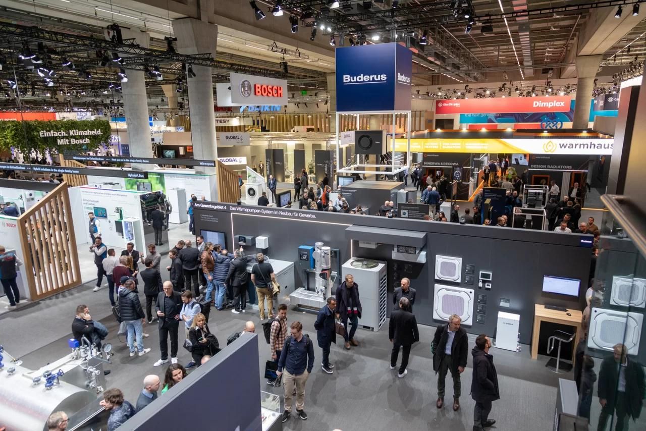 Bezoekers tussen de stands van warmtepompfabrikanten in een hal van ISH