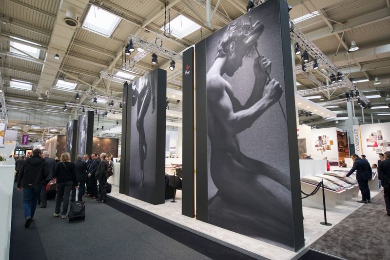 Zwarte panelen met grote zwart-witfoto’s aan de ingang van de stand