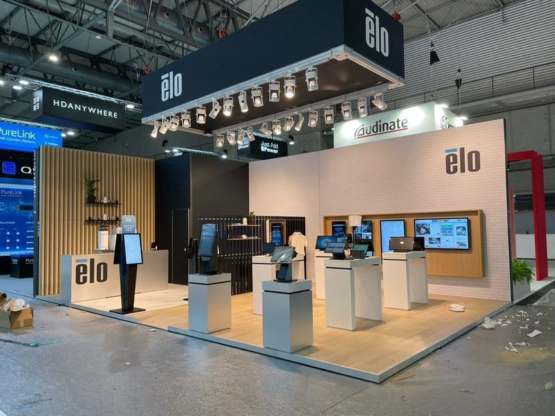 Stand van ELO met houten latten, witte wanden en touchscreens op zuilen