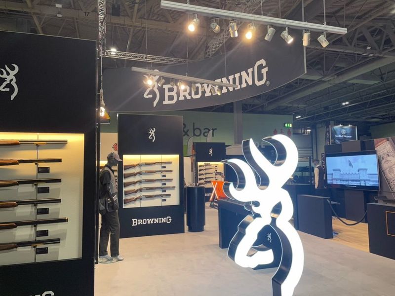 Groot verlicht logo van Browning naast een wapenwand