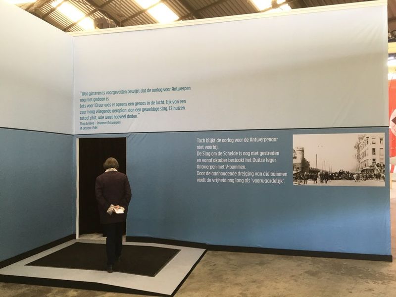 Lichtblauwe ruimte met tekstpanelen en een historische foto