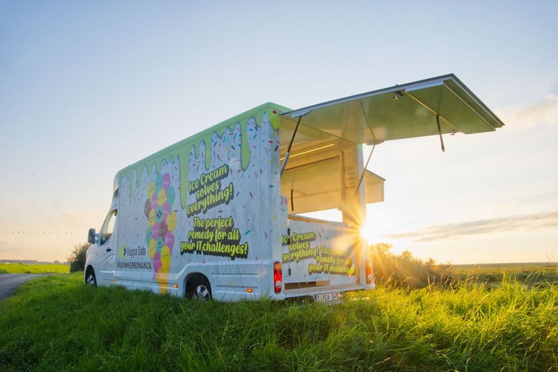 Bestickerde promowagen met open luifel bij zonsondergang