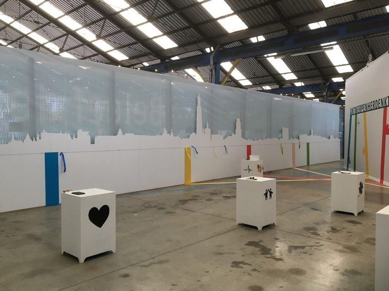 Witte sokkels met symbolen voor een wand met een stadssilhouet